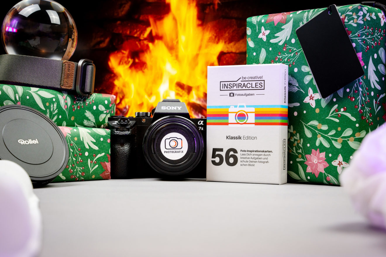 Geschenke und einige Fotoprodukte vor einem Kaminfeuer.